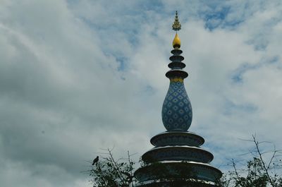 Low angle view of tower against cloudy sky