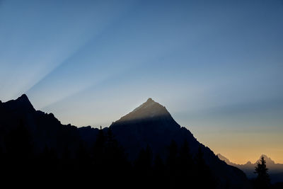 Silhouette mountain range against clear sky during sunset