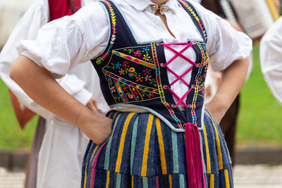 Midsection of woman holding multi colored umbrella