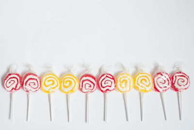 High angle view of multi colored candies against white background
