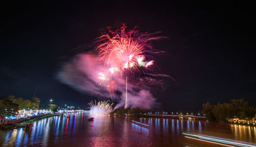 Firework display over river at night