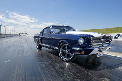 Vintage car on road against blue sky