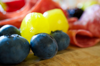 Close-up of grapes, berries and meats on table