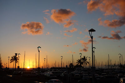 Cars on road against sky during sunset