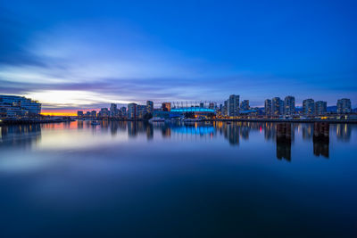 Reflection of illuminated buildings in city at dusk