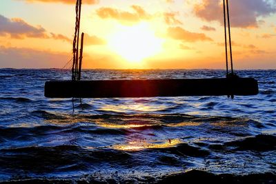 Sailboat in sea against sky during sunset