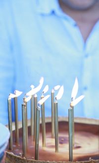 Midsection of woman holding lit candle