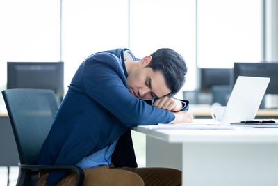Man using mobile phone while sitting on table