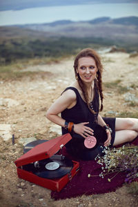 Portrait of young woman sitting on field