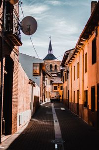 Alley amidst buildings in city against sky