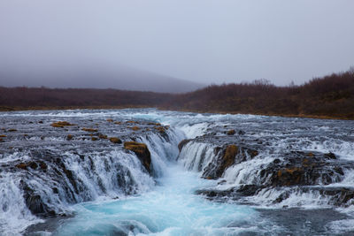 Scenic view of waterfall against clear sky