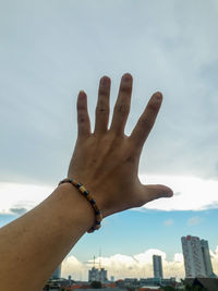 Low angle view of hand against sky