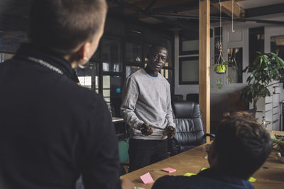 Computer programmer with coworkers discussing over start-up strategy at workplace