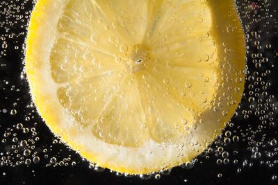 Close-up of water drops on glass against black background