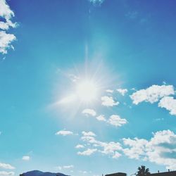 Low angle view of sun shining in blue sky