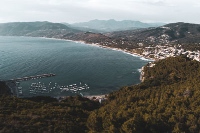 High angle view of sea and mountains against sky