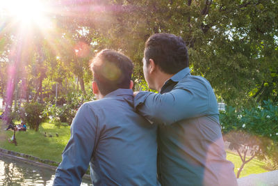 Rear view of gay couple at park