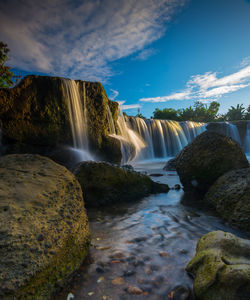 Low angle view of waterfall against sky