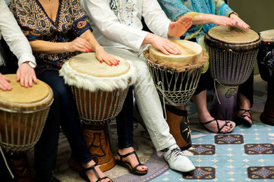 Low section of people playing drum at home