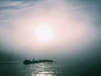 Boats in sea at sunset