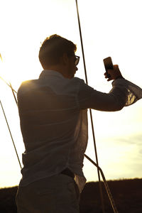 Man taking selfie while standing against sky