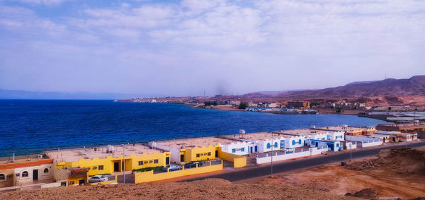 High angle view of sea and buildings against sky