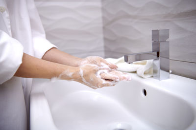 Midsection of woman in bathroom at home