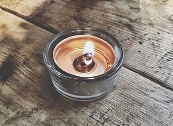 High angle view of illuminated candle on table