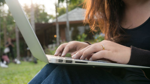 Midsection of woman using mobile phone outdoors