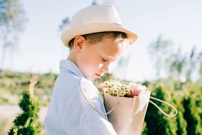 Midsection of woman holding red flowering plants