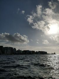 Cityscape by sea against sky