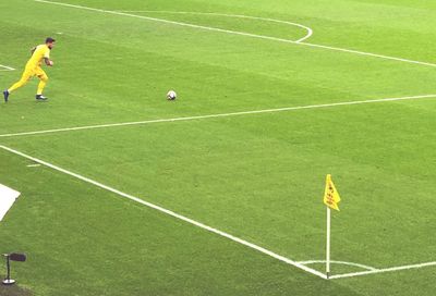 Man playing soccer ball on grass