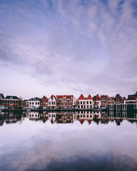 Reflection of buildings in lake against sky