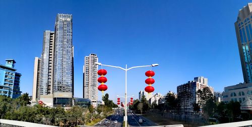 View of city street and buildings against blue sky