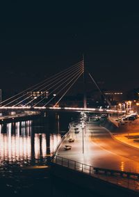 Illuminated bridge against sky at night