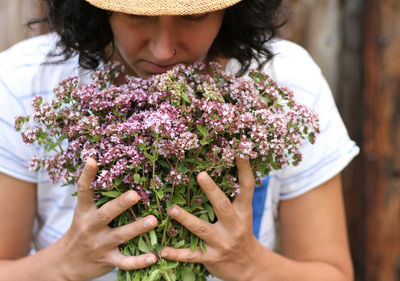 Midsection of woman holding purple flowering plant