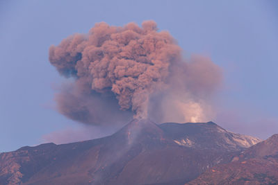 Panoramic view of the strombolian eruption of etna against the sky