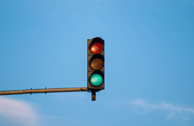 Low angle view of road signal against blue sky