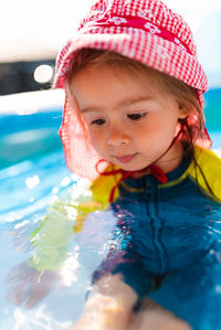 Child in inflatable swimming pool in backyard. proper sun protection for babys concept.