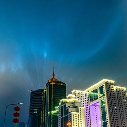 Low angle view of illuminated buildings against blue sky