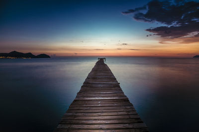 Pier over sea against sky at sunset