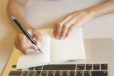 Midsection of woman using laptop on table