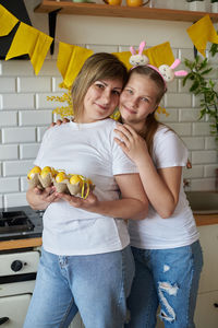 Mom and daughter posing with easter eggs in the kitchen