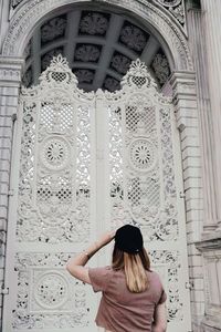 Rear view of woman standing against building