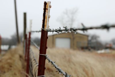 Close-up of barbed wire against sky