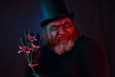 Portrait of bearded man playing guitar against black background