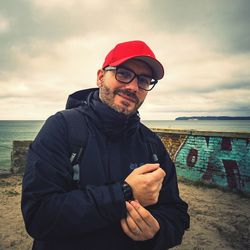 Portrait of man standing on beach against sky