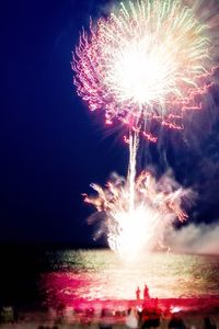 Low angle view of firework display at night