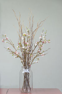 Close-up of white flower vase on table against wall