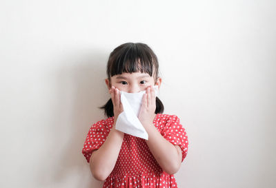 Portrait of a smiling young woman against white background